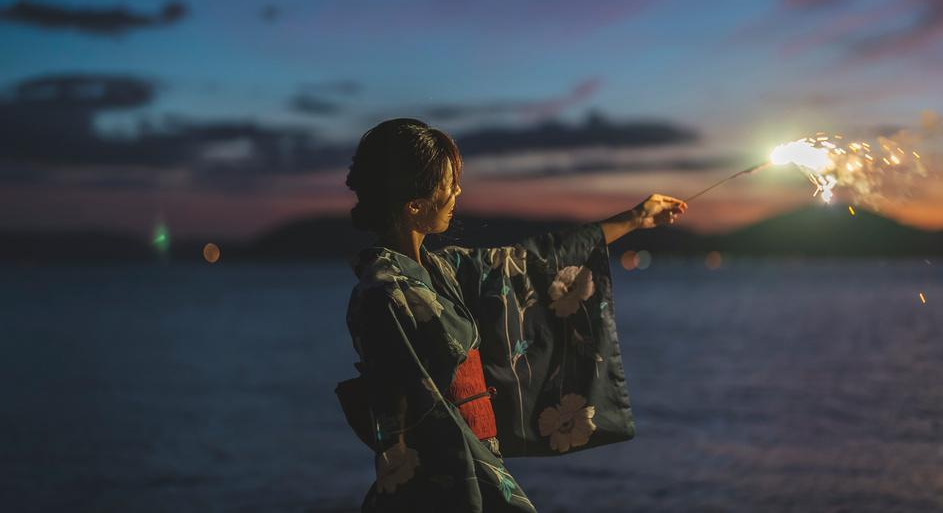 浴衣姿の女性が花火をしている